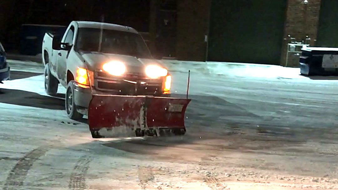 ISR Gardening plow truck clearing a commercial parking lot at night