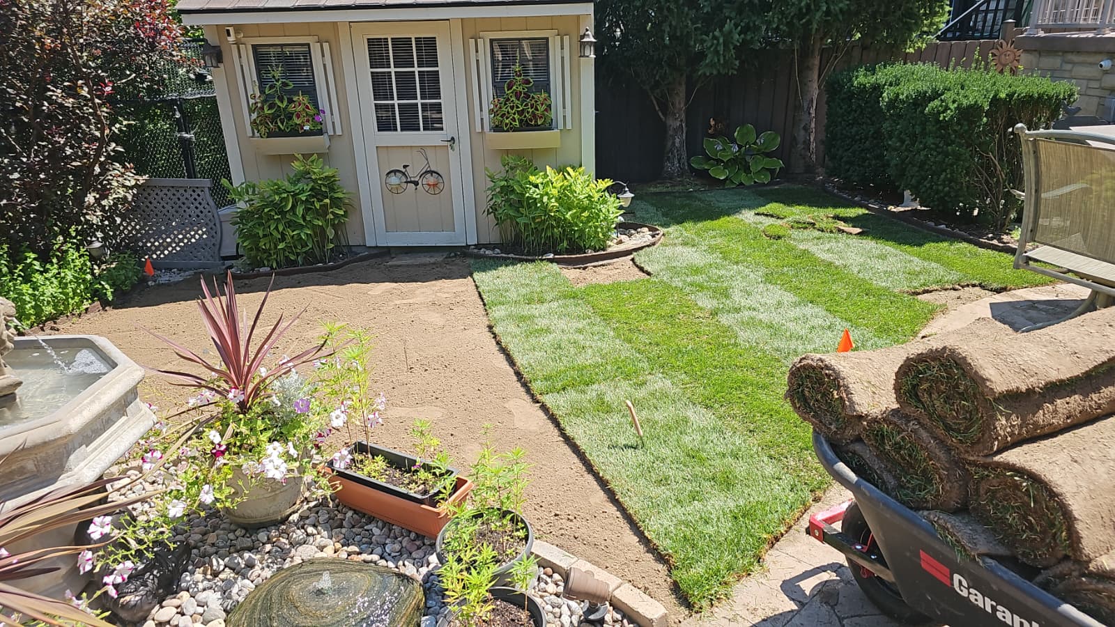 Freshly laid sod rolls and finished strips on an ISR Gardening install in the GTA, ready for fall watering before winter