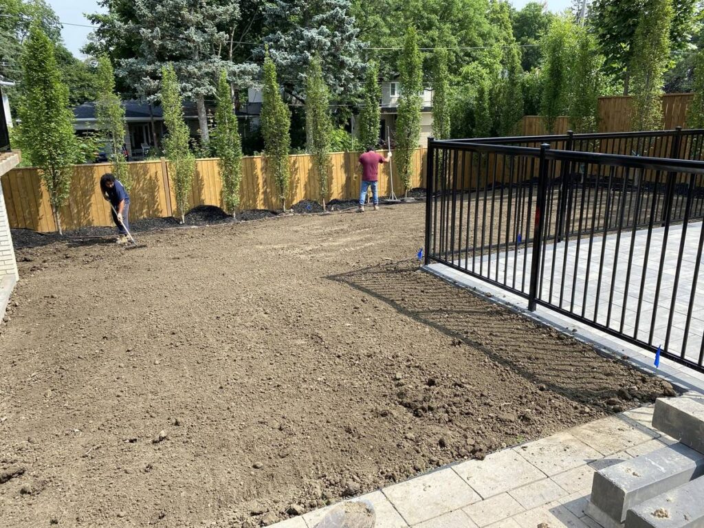 Backyard graded with topsoil and ready for sod beside a new pool in North York