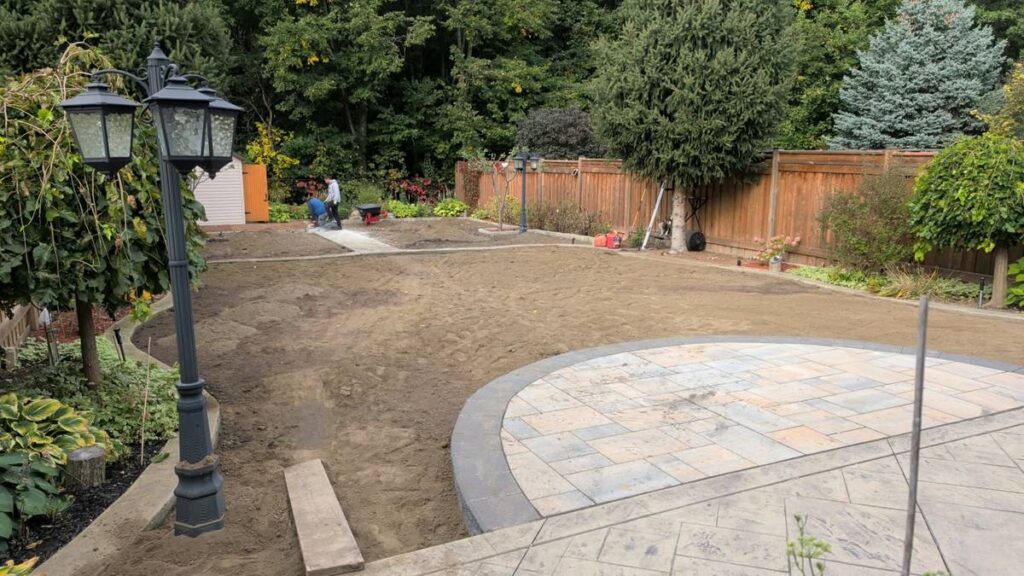 Backyard graded and prepared for sod around a stone patio in Vaughan