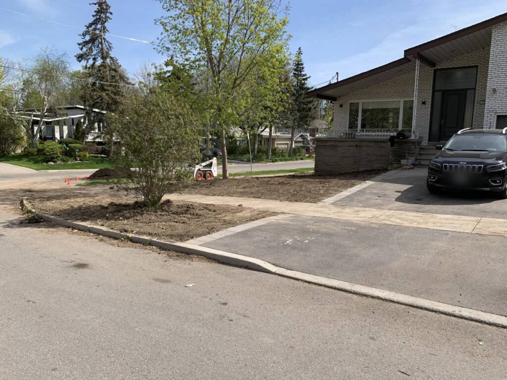Corner-lot front yard stripped and graded before new sod in North York