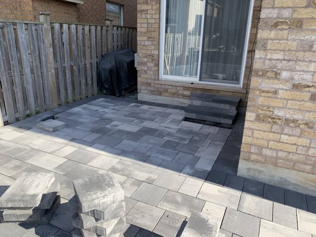 Finished grey interlocking patio behind a house