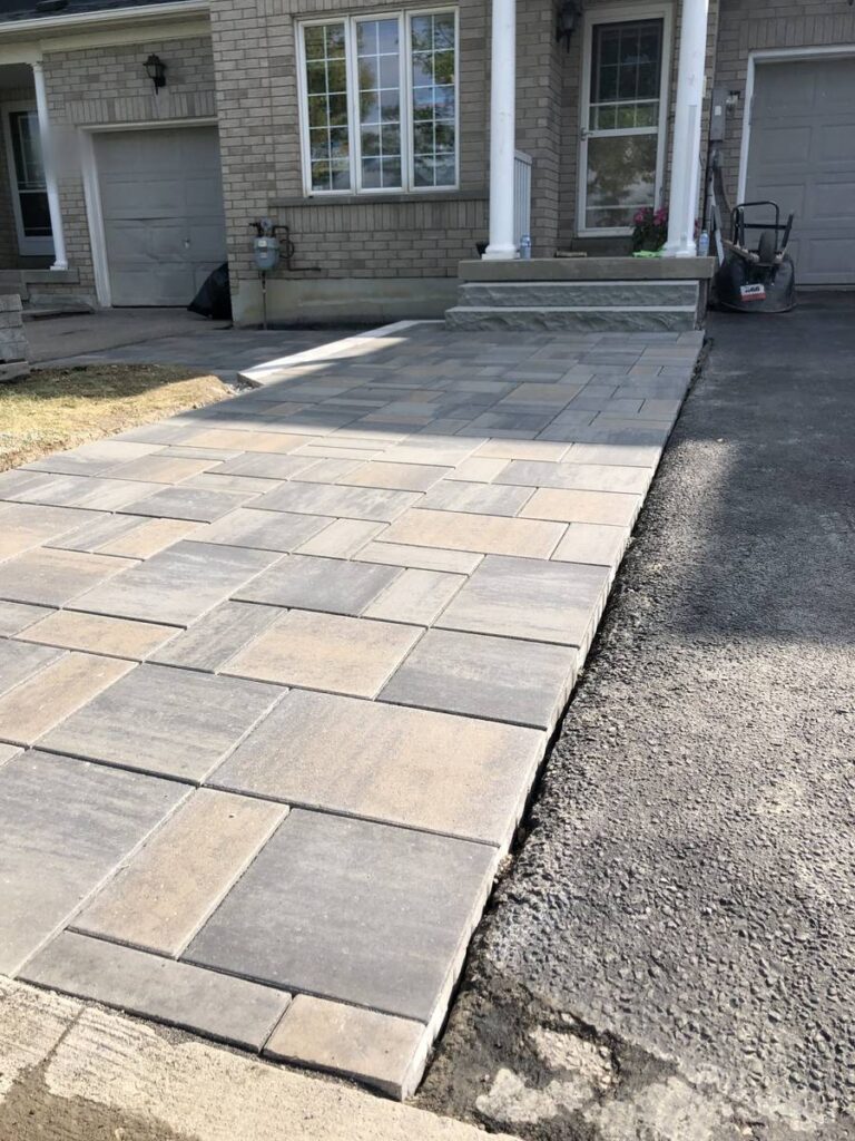 Interlocking paver driveway extension beside an asphalt driveway