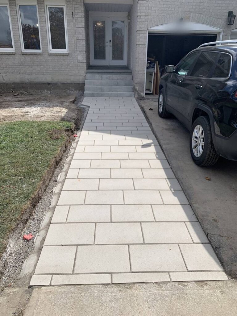 Light interlocking front walkway beside a driveway
