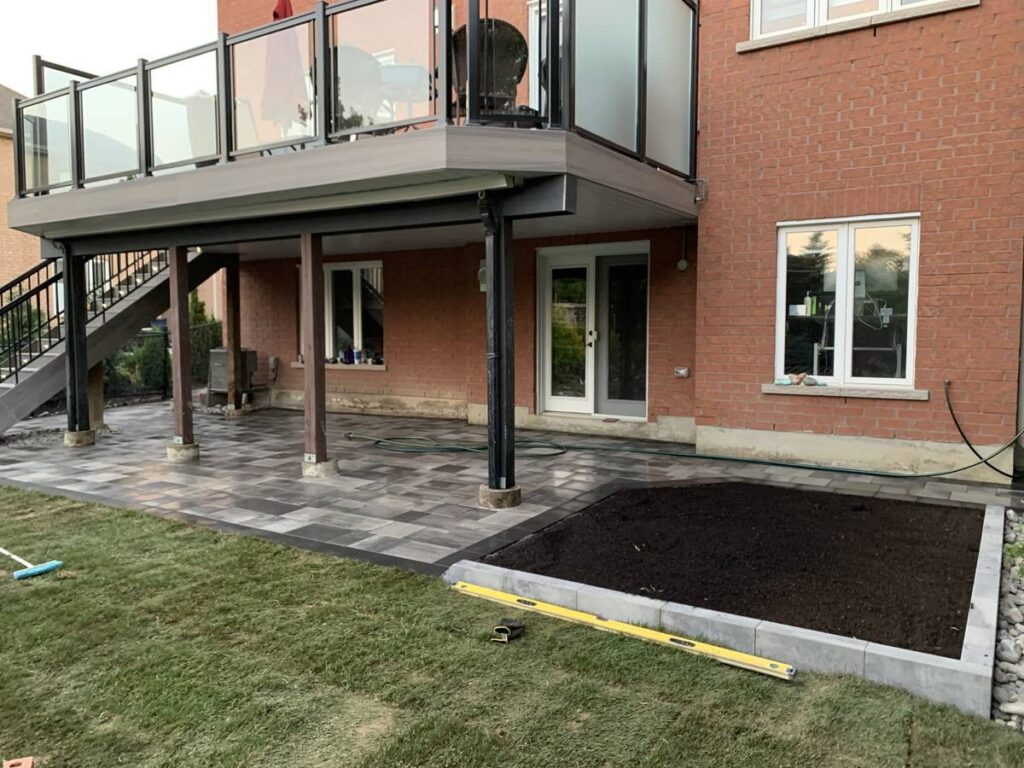 Interlocking patio installed under a raised backyard deck