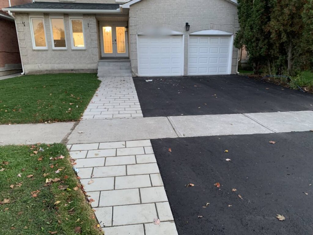 Interlocking walkway beside a new asphalt driveway