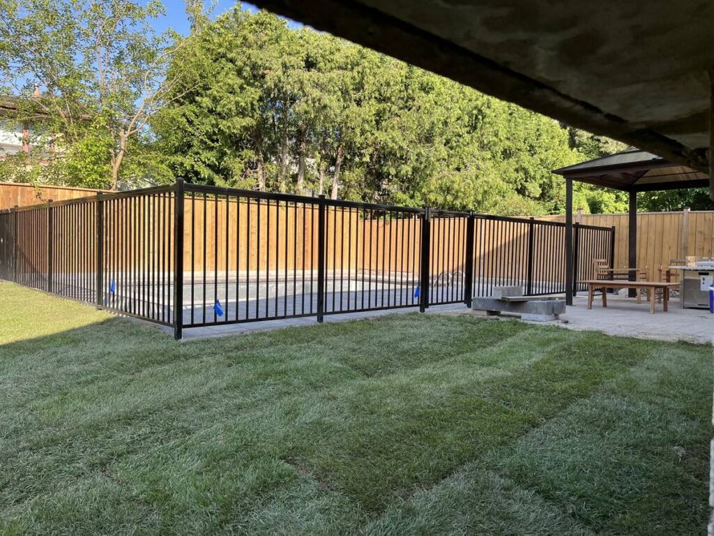 New sod lawn beside a fenced pool in a North York backyard